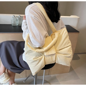 Détail du sac cabas jaune avec nœud en tissu plissé léger et bandoulière large confortable