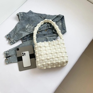Top view of cream-colored quilted puffer shoulder bag with interior storage space