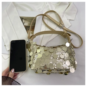 Detail of champagne gold sequin handbag showing reflective metallic texture and strap