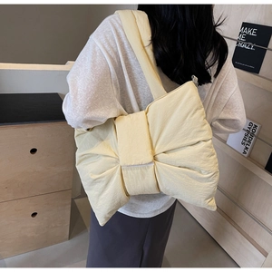 Vue latérale détaillée du grand sac bandoulière en nylon jaune pâle forme nœud