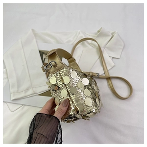 Detailed macro view of golden sequins and metallic hardware on a fashion handbag