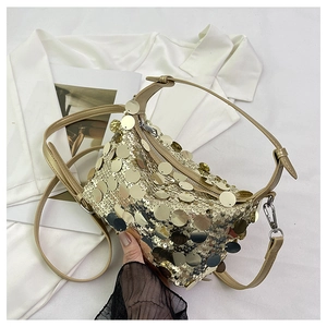 Detail of shimmering gold sequin evening bag with zipper closure and beige leather strap