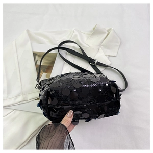 Detail of shimmering black sequin crossbody bag with slender leather strap and silver buckle