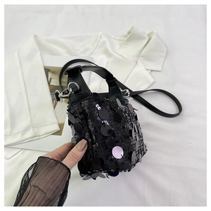 Detail of black sequined bucket bag with leather handles and silver metal hardware