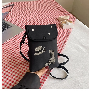 Detail of black crossbody phone bag with rhinestone hat and boot patterns