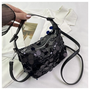 Detailed view of black sequin handbag featuring a metallic zipper and leather handle