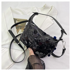 Close-up of black sequined crossbody bag with metallic silver zipper and leather strap