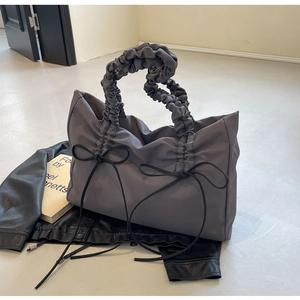 Detail van grijze grote shopper met strikdecoratie en geplooide handgrepen