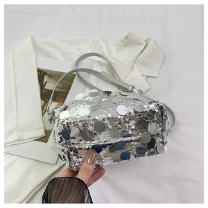 Close-up of the silver sequin handbag showing reflective metallic round scales and strap