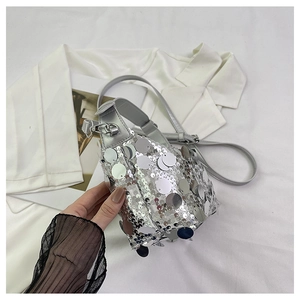 Macro view of sparkly silver sequins and metal buckle detail on a stylish crossbody bag