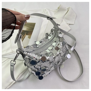 Detail of silver sequin handbag with metallic glitter texture and crossbody strap