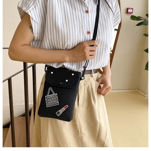 Detailed view of black crossbody phone bag featuring rhinestone lipstick pattern design