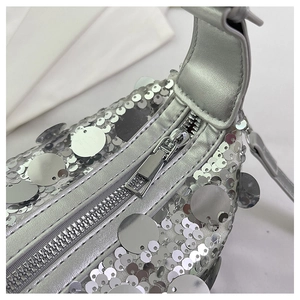 Detail view of silver sequins craftsmanship and smooth metallic zipper on the handbag