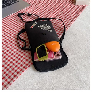Detail of black mini crossbody bag with rhinestone lipstick pattern and inner storage