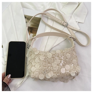 Close-up of a mini sequined handbag in cream white with adjustable shoulder strap detail