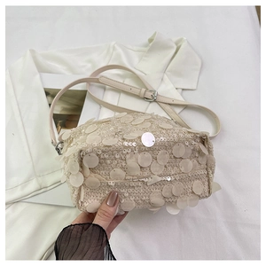 Detailed macro view of large ivory sequins and adjustable strap on the fashion handbag