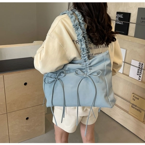 Detail van de lichtblauwe nylon draagtas met geplooide bandjes en stijlvolle strikjes