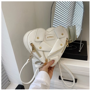 Detail of white heart-shaped crossbody bag with moto jacket style zippers and gold studs