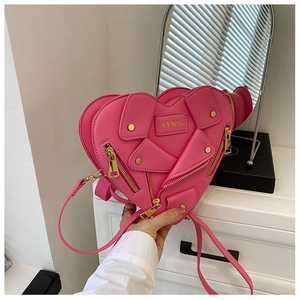 Detailed macro view of pink heart-shaped bag with biker jacket zipper and stud details