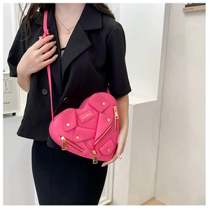 Detail of hot pink heart shaped biker jacket handbag with gold zippers and metal logo