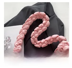 Close-up of pink bubble pleated texture and soft ruffled handle on the polyester handbag