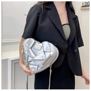 Detail of silver heart-shaped crossbody bag with punk motorcycle jacket style design