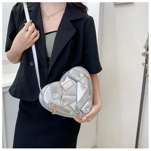 Close-up of heart-shaped silver biker jacket crossbody bag with metallic zipper and rivets