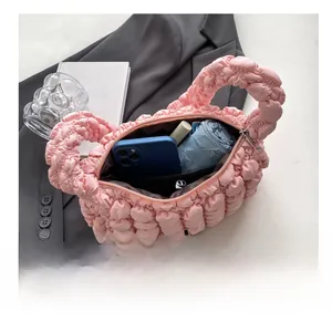 Interior capacity of the pink pleated bubble bag showing phone and umbrella storage