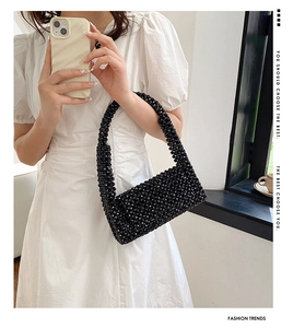 Detail of a handmade black beaded half-moon shoulder bag with retro punk style rivets