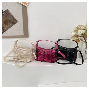 Detail view of sparkly sequin handbags in beige, rose red, and black with shoulder straps