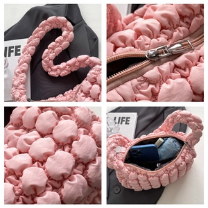 Detail view of pink bubble puff handbag showing quilted texture and interior storage capacity