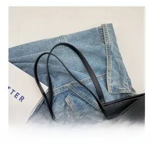 Detail showing the comfortable wide black leather shoulder strap of the tote bag