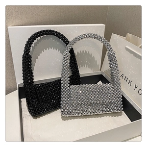 Detailed view of handmade beaded handbags in glossy black and metallic silver finishes