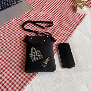 Mini black crossbody bag with rhinestone lipstick design on red checkered background