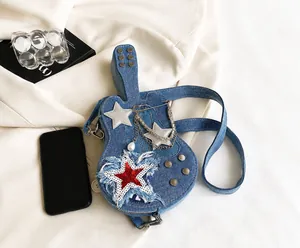 Macro view of blue denim guitar-shaped crossbody bag with sequin stars and chain details