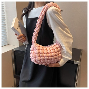 Close-up of pink bubble textured quilted fabric on a stylish ruched shoulder bag