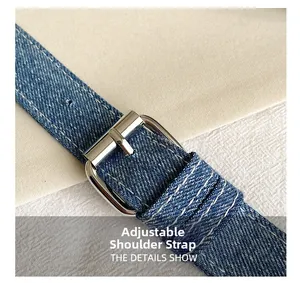 Dettaglio della tracolla regolabile in denim con fibbia argento e cuciture bianche