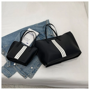 Detail of black nylon tote bag set featuring stylish triple vertical white stripes
