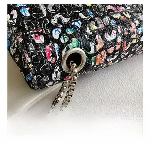 Macro shot of high-quality silver metal chain and eyelet details on a graffiti style bag