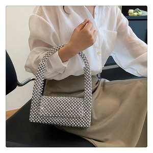 Close-up of a silver beaded handmade evening handbag with metallic reflective texture