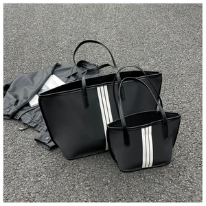 Detail of black striped nylon tote bag set showing waterproof fabric and ribbon trim