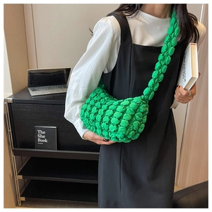 Detailed texture of green bubble puff bag featuring unique ruched fabric and wide strap