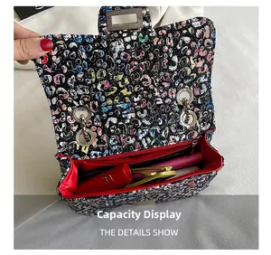 Detail view showing red interior of graffiti print chain bag and daily essentials capacity