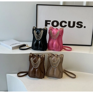Detail of four creative female torso shaped crossbody bags with multi-layer metal chains