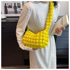 Detail of yellow bubble cloud bag showing textured pleated fabric on model's shoulder