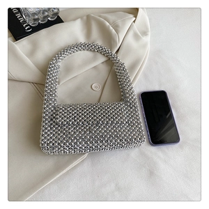Detail of silver beaded handbag texture on beige blazer with chic lifestyle props
