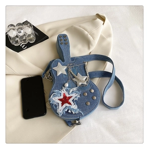 Dettaglio della borsa a chitarra in denim blu con paillettes a stella e catene d'argento