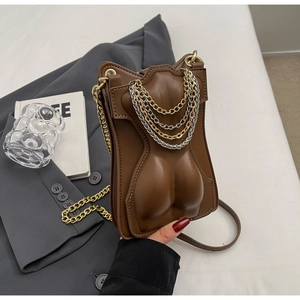 Detail of a brown leather crossbody bag with artistic torso embossing and layered chains
