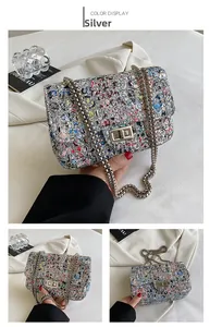 Detail of silver chain bag featuring colorful graffiti prints and metallic lock closure