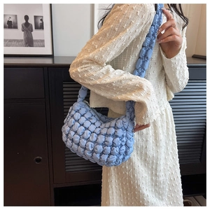 Close-up of light blue bubble textured cloud bag showing ruffled shoulder strap detail